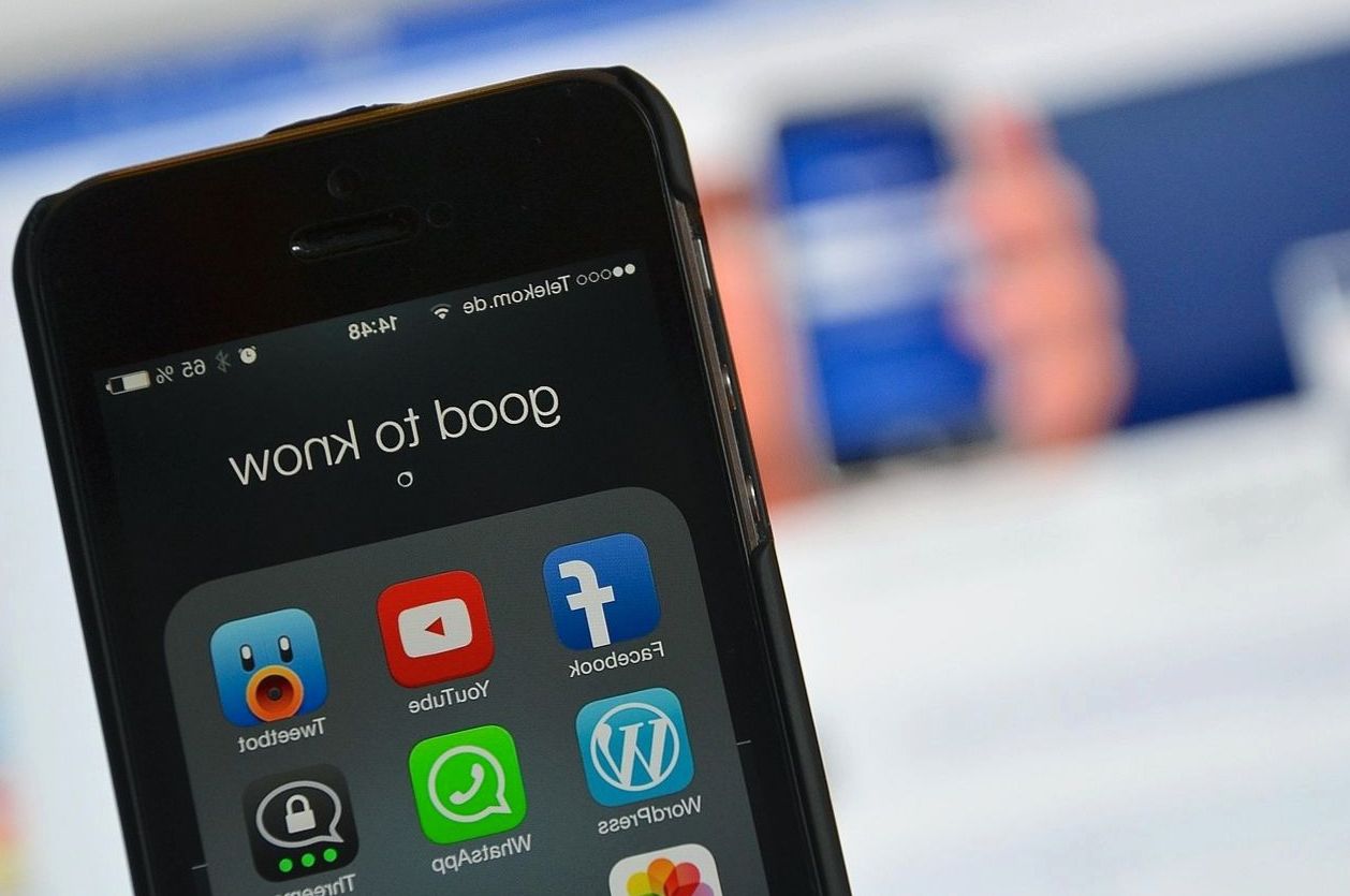 Smartphone showing a folder of social media apps including Facebook and YouTube